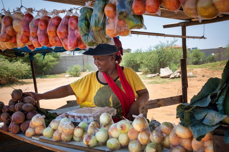 Produce vendor at a busy market